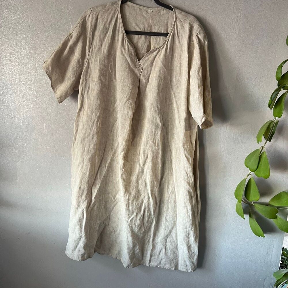 beige, short-sleeve linen tunic dress with a V-neck and front button detail.